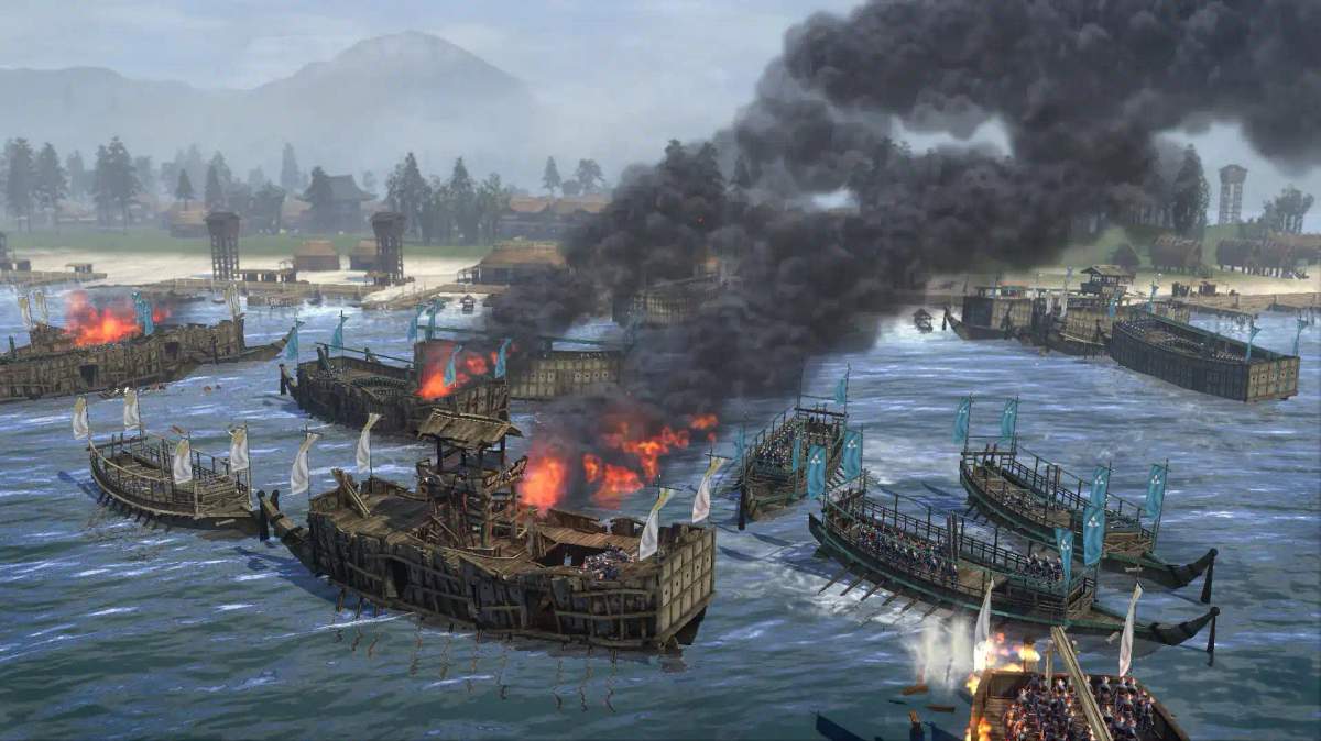 Isang labanan sa dagat sa Total War: Shogun 2 na nagpapakita ng mga nasusunog na barko at mga sundalo sa isang baybayin.